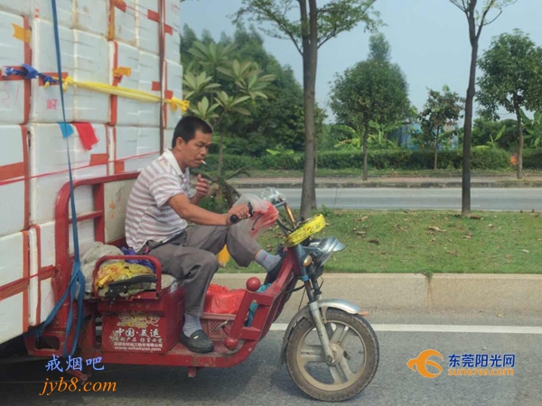 超载司机开车“玩杂技” 翘脚开车还吸烟